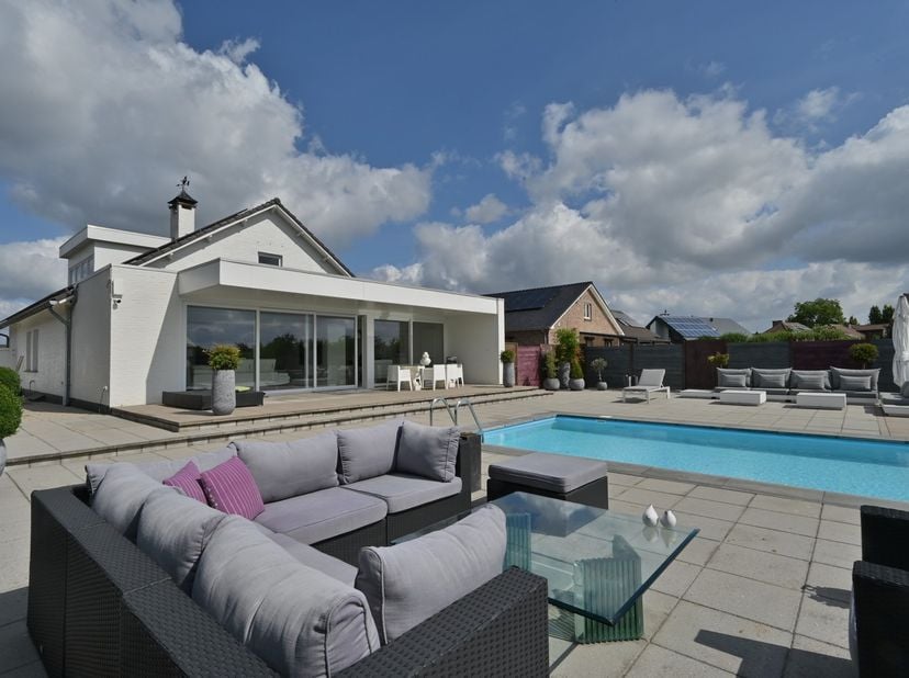 Deze hedendaagse woning in een rustige woonwijk van Rekem ligt aan het einde van een doodlopende straat en biedt een prachtig, open uitzicht over de v