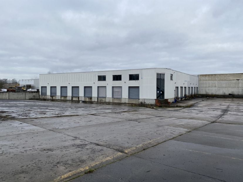Te huur: magazijn van ±2.000m² met een vrije hoogte van 6m, inclusief een kantoorruimte van ±150m², laadkades, een toegangshelling en 2 sectionaalpoor