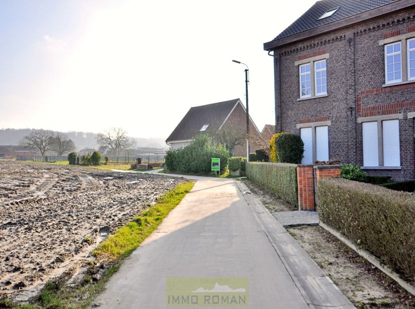 In een verkeersluwe straat aan de dorpskern van Ruien, deelgemeente van Kluisbergen treffen we deze bouwgrond voor een halfopen bebouwing. Zéér rustig