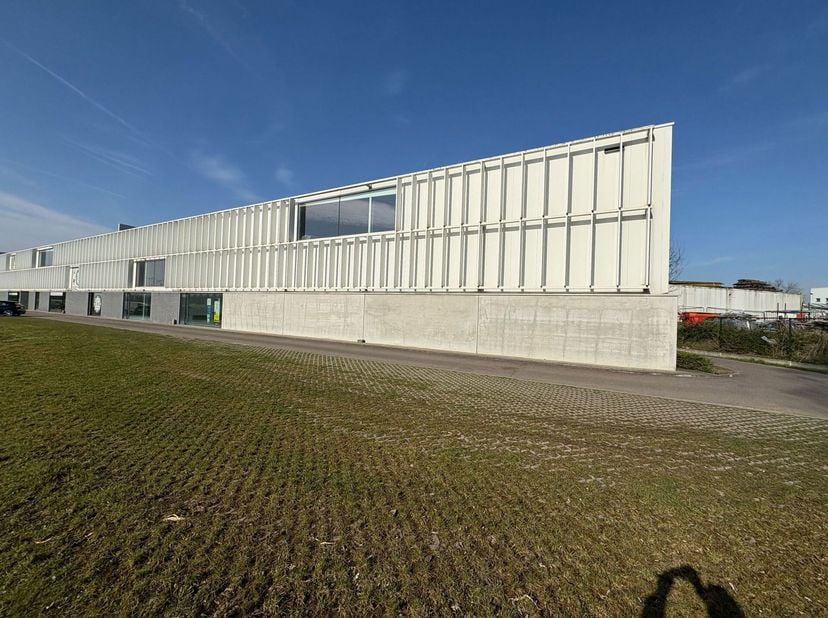 Te huur: Magazijnunits 11-12 met een totale oppervlakte van 836m², inclusief een klein kantoor van 15m² en sanitair. Gelegen vlakbij de afrit Kruibeke