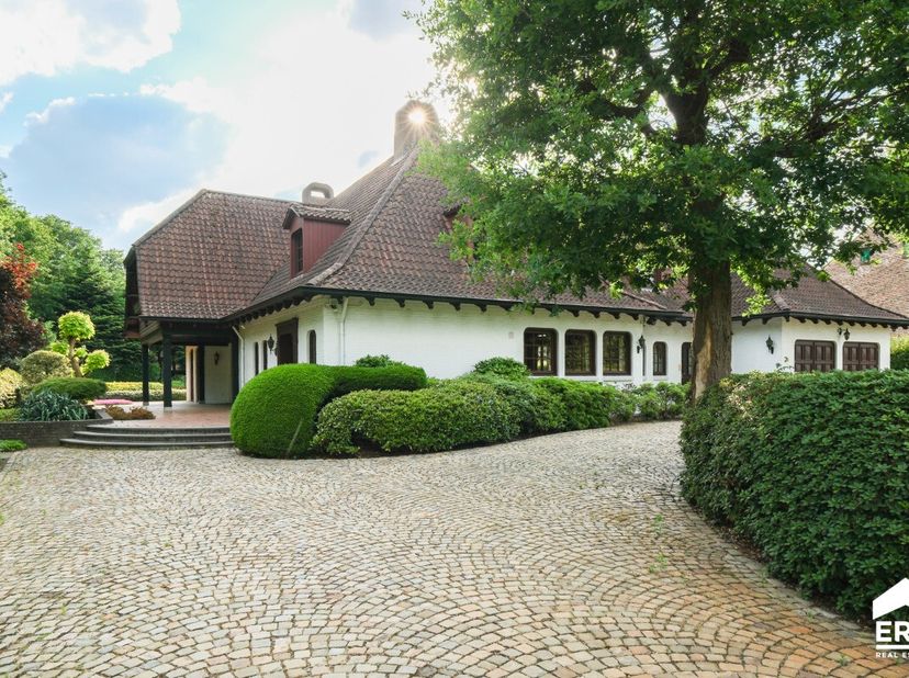 Karaktervolle villa, gebouwd in 1980, met uitzonderlijke woonoppervlakte op een prachtig perceel van 25a 50ca (straatbreedte 37m50) te Houthalen.Voor