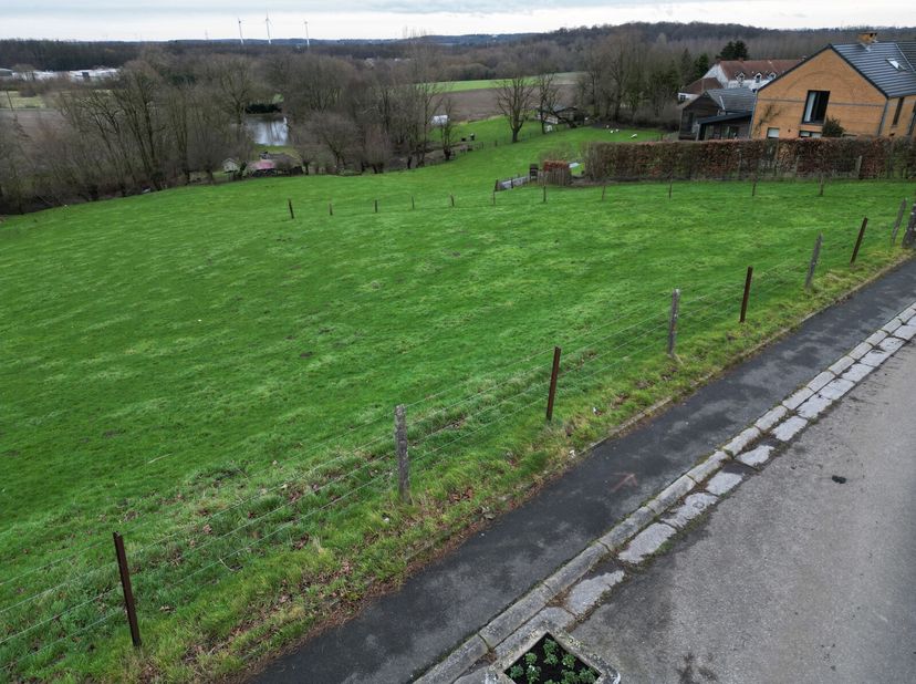 Vous rêvez de construire dans un cadre paisible avec vue dégagée sur la nature ? Ce terrain à bâtir vous séduira par sa large façade à front de voirie