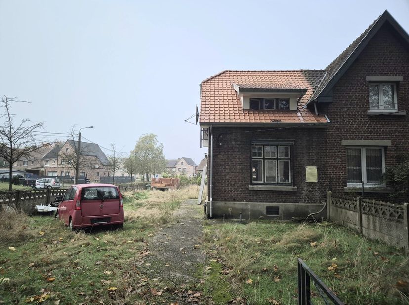 Ontdek deze charmante halfopen woning in de rustige tuinwijk van Genk, gelegen op een ruim perceel van 5,65 are. Dit huis biedt een unieke kans om een