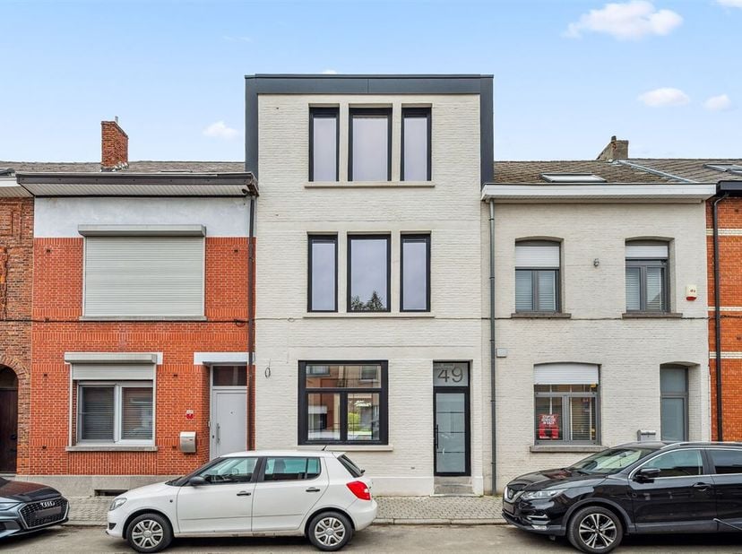 Dit huis ligt op wandelafstand van station en scholen, met een officiële Mobiscore van 9,4 op 10. Het kaleiwerk en de zwarte ramen geven deze bijzonde