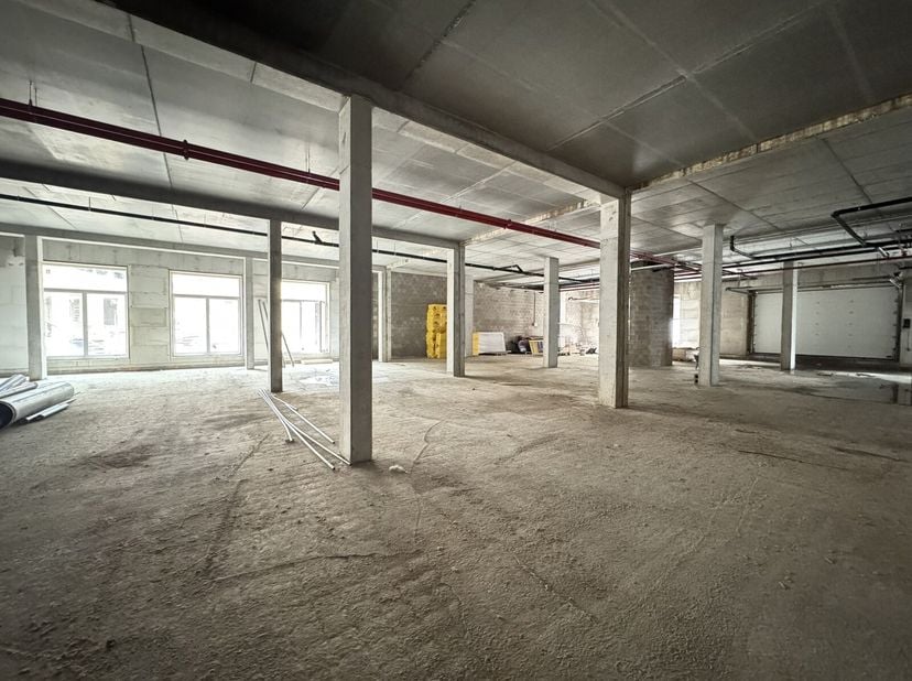 Gelegen in het Tannat-project in het hart van Molenbeek, integreert deze prachtige CASCO commerciële ruimte van 1.231 m² zich in een wijk die volop in