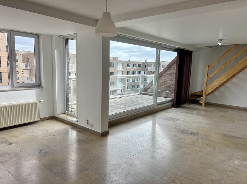 Duplex appartement op de 4de verdieping op een rustige ligging te Blankenberge dichtbij de Zeedijk. Gelijkvloers: woonkamer met zeer ruim en zonnig te