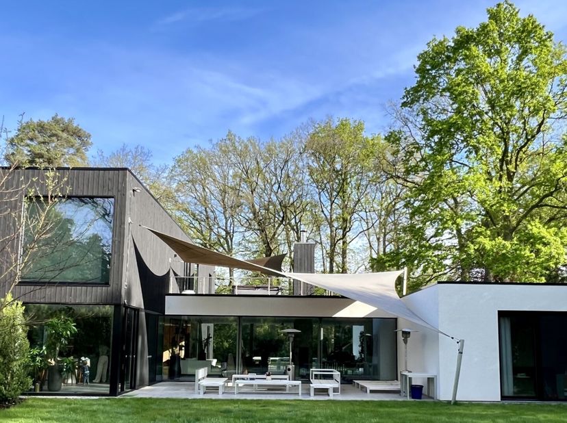 Dit uitzonderlijke eigendom, gelegen op een prachtig perceel van 3.434 m² in het residentiële Schotenhof, combineert verfijnde architectuur met hedend