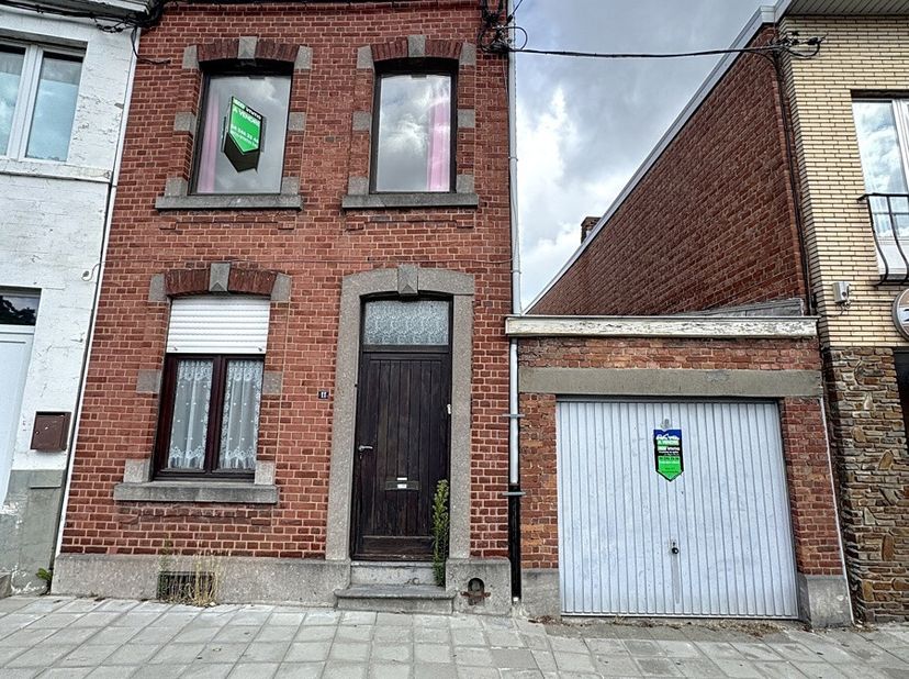 Située à proximité des commodités, cette maison mitoyenne à rénover offre une superficie habitable de 71 m², excluant les caves, le garage et le greni
