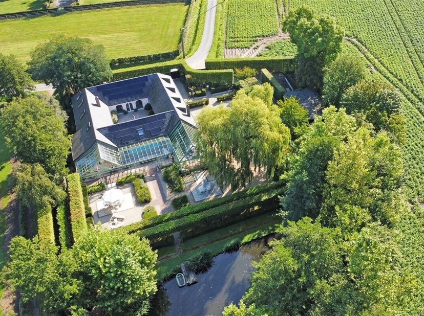 Achter een afgesloten toegangspoort met prachtig aangelegde binnenkoer bevindt zich deze charmante vierkantshoeve, welke door de jaren heen een volled