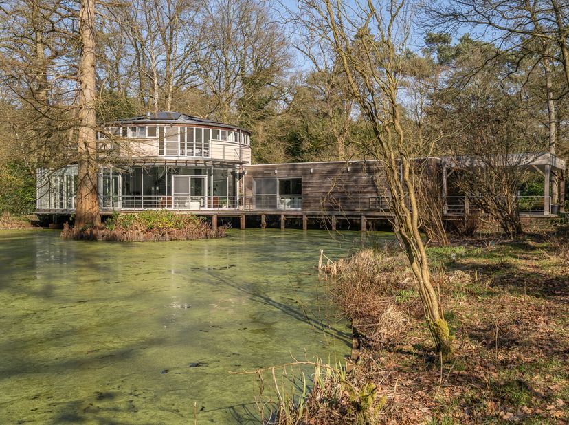 Wonen in harmonie met de natuur. Deze unieke, recent geactualiseerde woning is ontworpen om het prachtige bosgebied en de vijver naadloos te integrere
