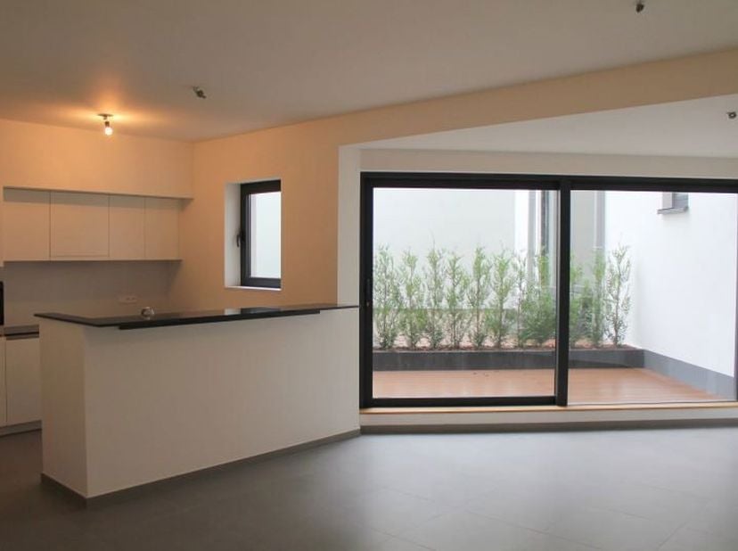 Situé dans un immeuble récent (2015) face à la place du Trône, lumineux appartement 1 chambre de 79 m² + terrasse au rez comprenant : hall d’entrée, s