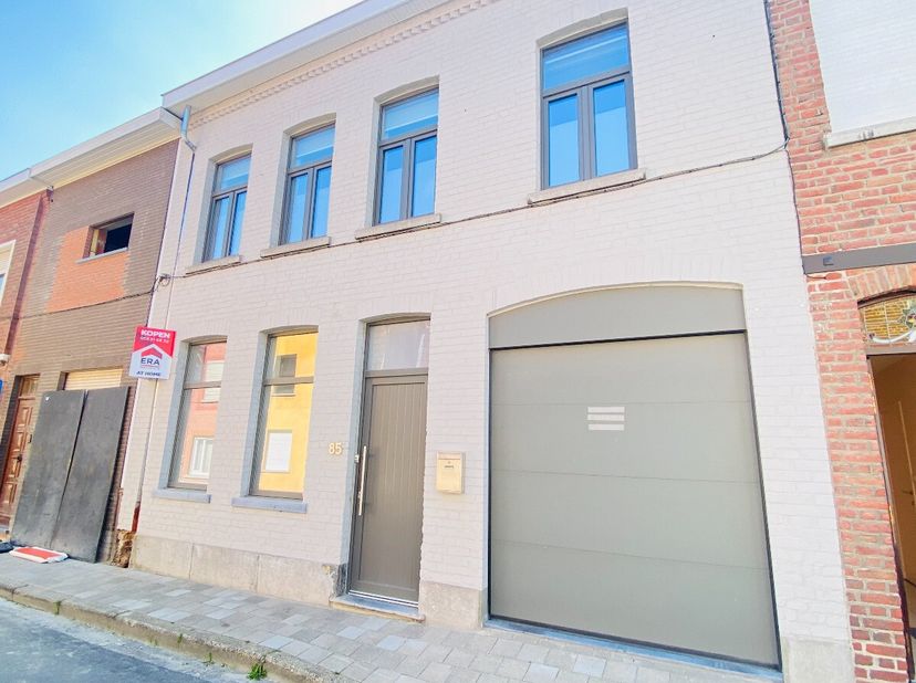 Volledig gerenoveerde woning met 4 slaapkamers, garage, terras en tuinInkomhal met toegang tot de garage. Grote garage met voorziening voor wasmachine