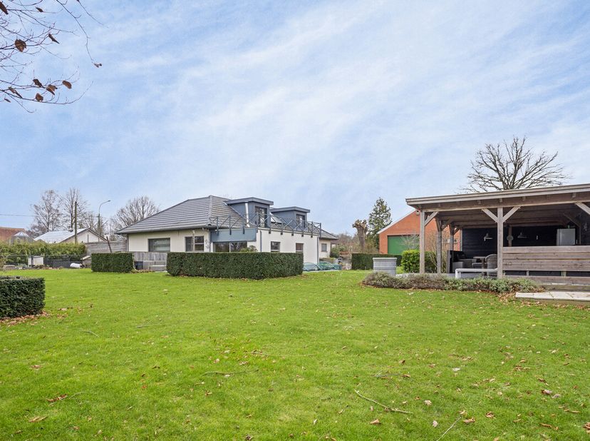 De woonkamer (ca. 30m²) beschikt over grote raampartijen, een houtkachel en heeft een parketvloer. De eetkamer (ca. 24m²) op parket beschikt over een