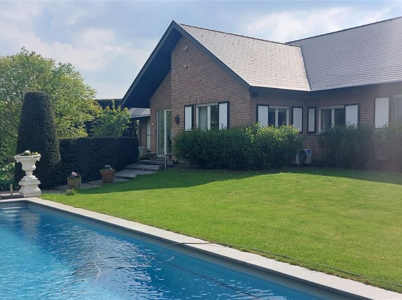 Op een rustig perceel van 1.480 m² ligt deze verrassend ruime woning. De 3-delige hal heeft een sierlijke tegelvloer. De woonkamer heeft een haard (ho