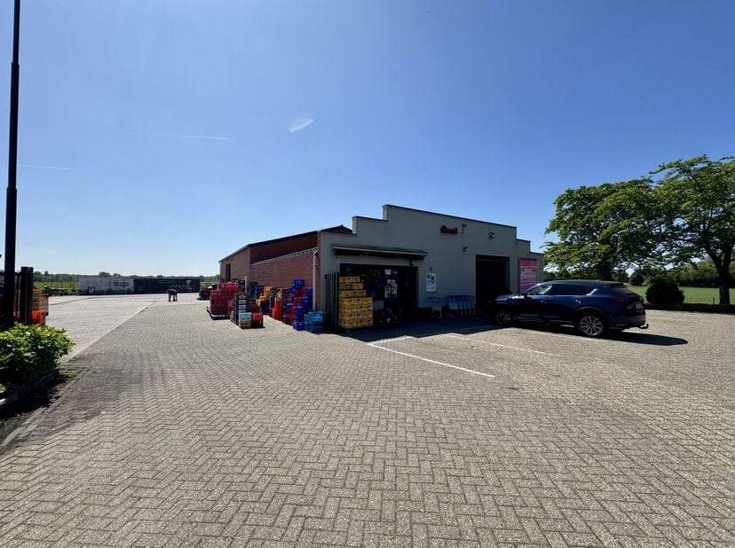 Ruim magazijn / opslagplaats bestaande uit een ruime buitenruimte (koer, betonverharding) van ong. 890m² (ong. 20x40m) en een gebouw met 2 compartimen