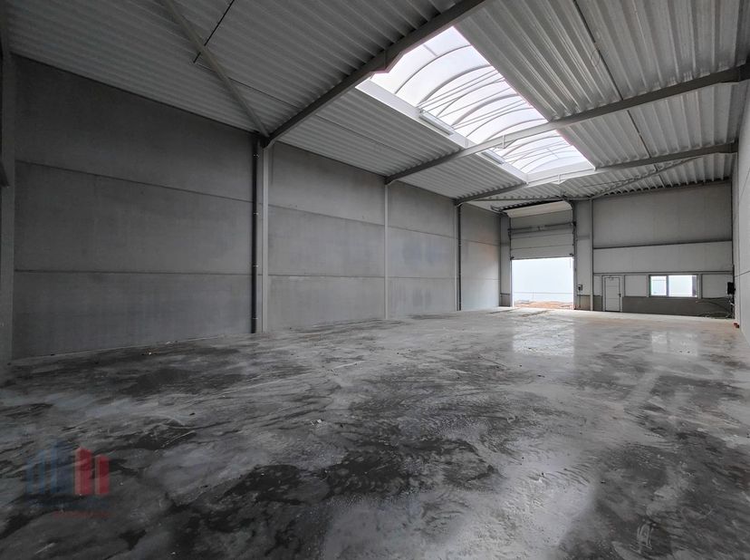 De casco loods van 440 m² heeft een vrije hoogte van 6 m en is opgebouwd uit een staalstructuur met betonplint in combinatie met geïsoleerde sandwichp