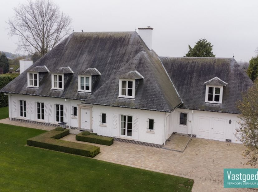 Gelegen aan de rand van het centrum van Zottegem, omgeven door groen en volledig afgesloten, vindt u deze unieke villa met praktijkruimte. Met een ind