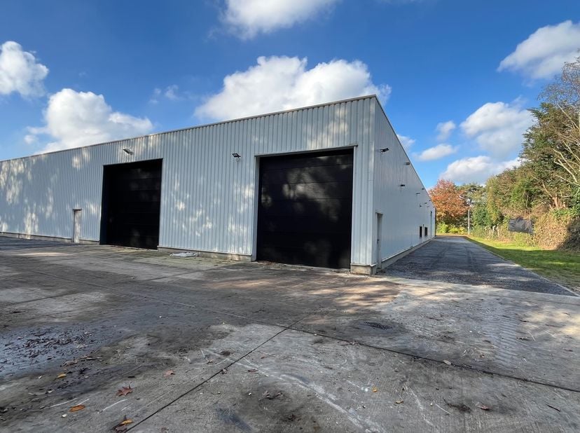 Dit bedrijfsgebouw van 750m² met een vrije hoogte van 4,5m beschikt over ingebouwde kantoren met mezzanine bestaande uit kitchenette, 2 douches en toi