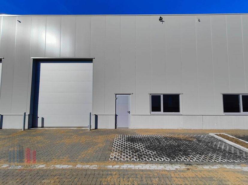 De casco loods van 332 m²  heeft een vrije hoogte van 6 m en is opgebouwd uit een staalstructuur met betonplint in combinatie met geïsoleerde sandwich